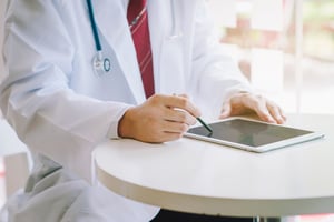 doctor using a tablet on a table