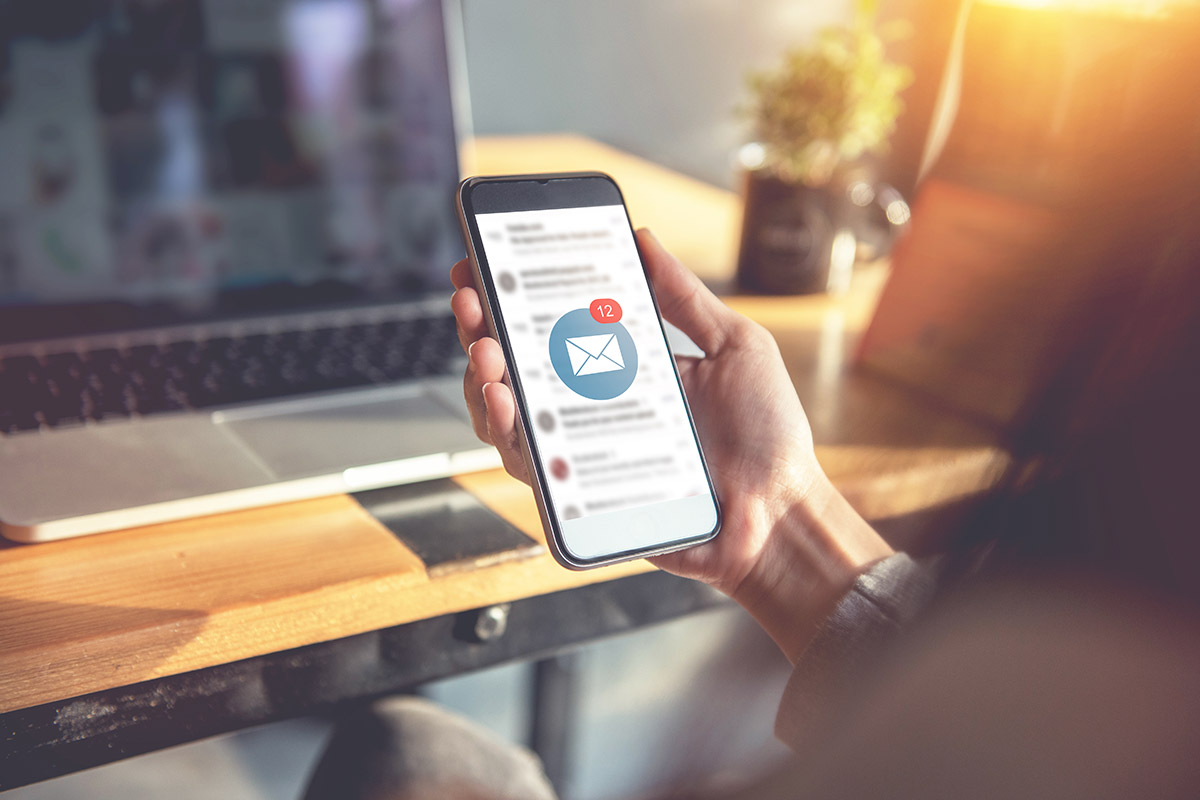 person looking at their mobile phone to check their email inbox