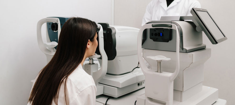 Patient undergoing an eye exam with diagnostic equipment at an optometry clinic.