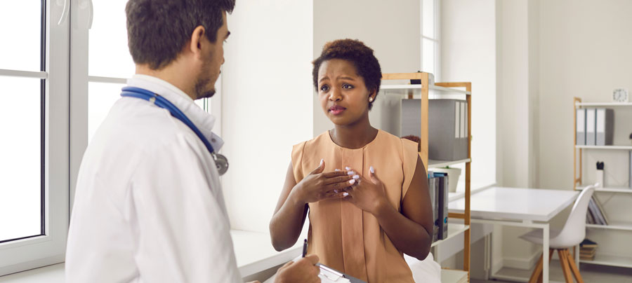 Patient speaking with a doctor during an office visit.